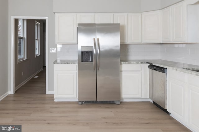 kitchen featuring decorative backsplash, white cabinetry, stainless steel appliances, and light hardwood / wood-style floors