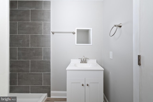 bathroom featuring a tile shower and vanity