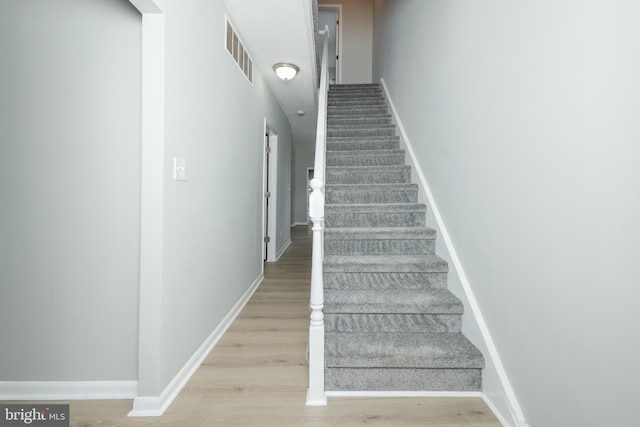 staircase with wood-type flooring