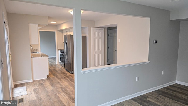 corridor with sink and dark wood-type flooring