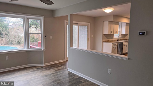 kitchen featuring dark wood-type flooring, white cabinets, sink, decorative backsplash, and black dishwasher