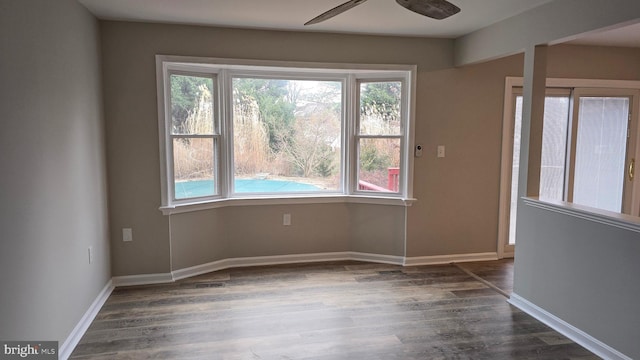 unfurnished room featuring dark hardwood / wood-style floors and ceiling fan