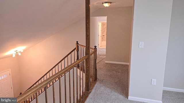 hallway with carpet flooring and lofted ceiling