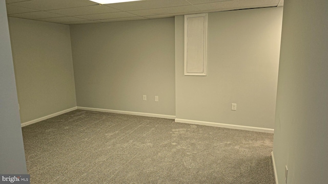 unfurnished room featuring carpet and a paneled ceiling