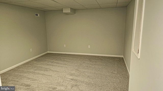 carpeted spare room featuring a paneled ceiling