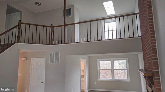 stairs with a skylight and a high ceiling