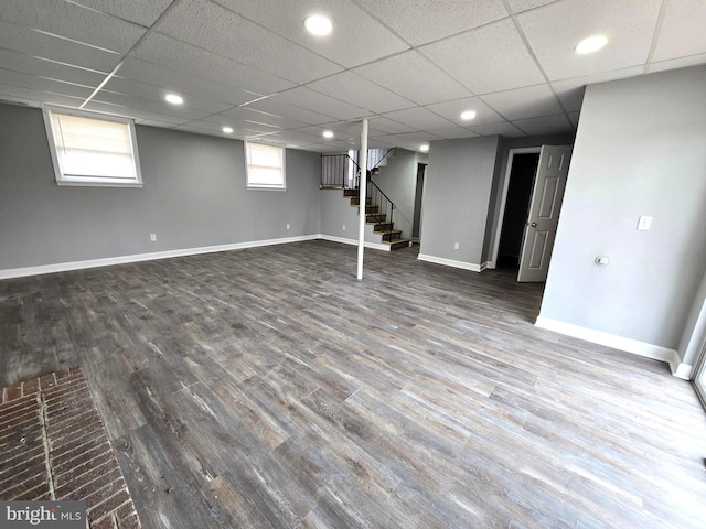 basement featuring a paneled ceiling and wood-type flooring