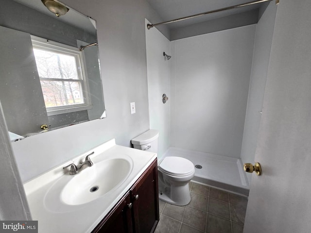 bathroom with tile patterned flooring, vanity, toilet, and a shower