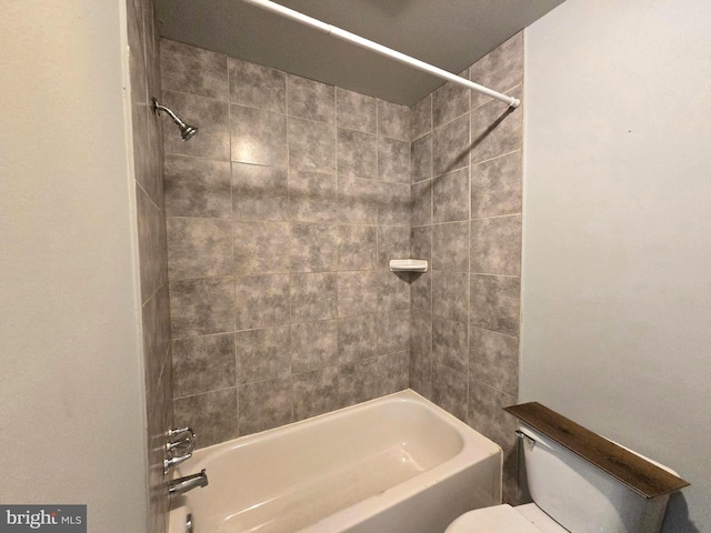 bathroom featuring toilet and tiled shower / bath