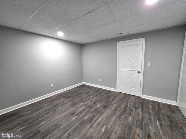 unfurnished room with a paneled ceiling and dark wood-type flooring