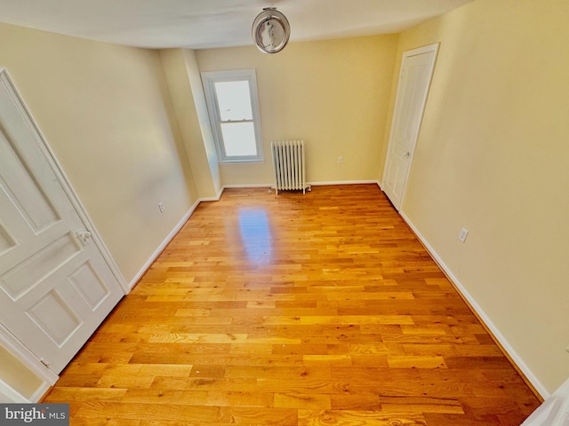 spare room featuring light hardwood / wood-style floors and radiator