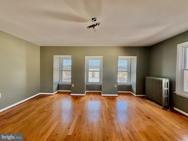 spare room with light wood-type flooring and radiator