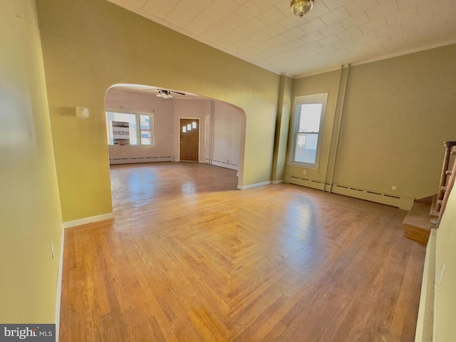 spare room with ornamental molding, ceiling fan, and a baseboard heating unit