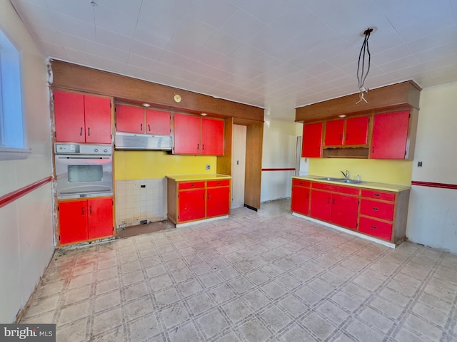 kitchen featuring range hood, oven, and sink