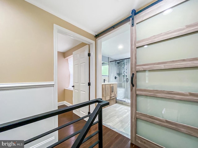 corridor featuring a barn door and dark wood-type flooring