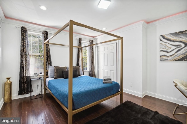 bedroom with dark hardwood / wood-style floors, ornamental molding, and a closet