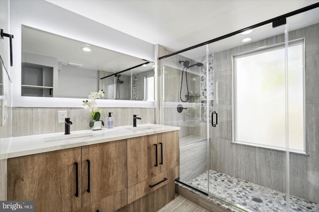 bathroom featuring vanity, a healthy amount of sunlight, and a shower with shower door