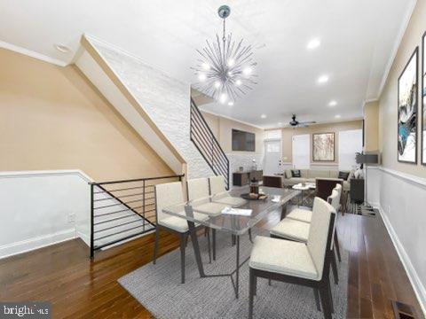 dining space with ceiling fan with notable chandelier, dark hardwood / wood-style flooring, and crown molding