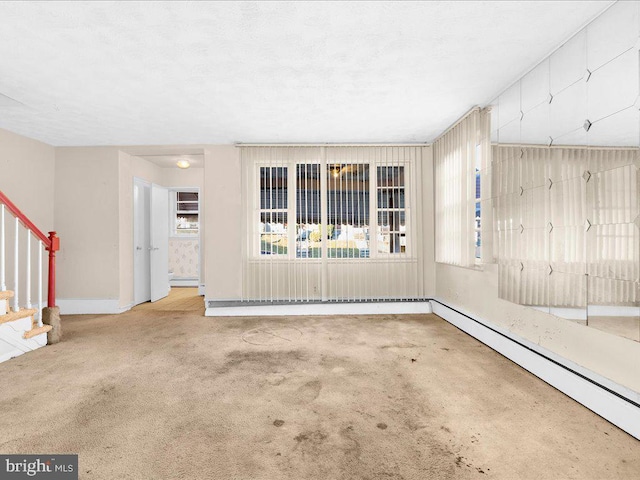 carpeted spare room with a baseboard radiator