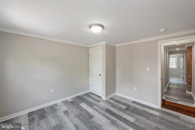 spare room with crown molding and hardwood / wood-style flooring