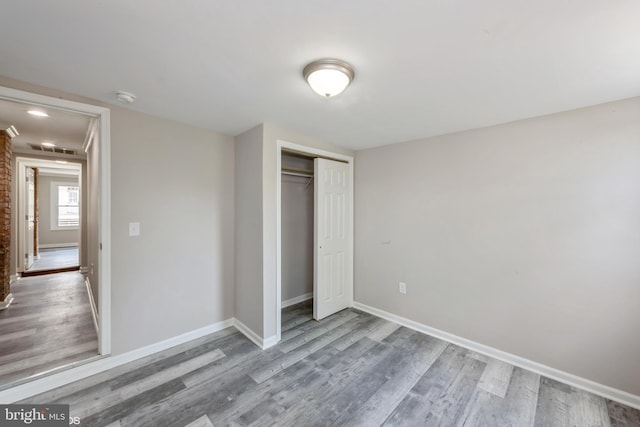 unfurnished bedroom with a closet and wood-type flooring