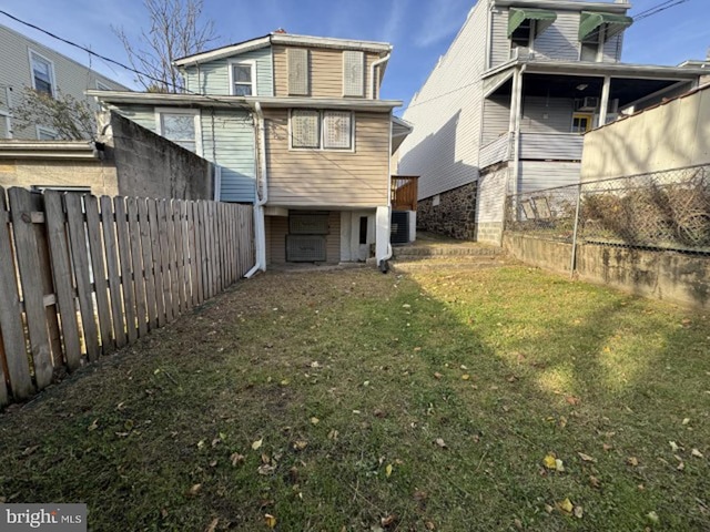 rear view of house featuring a yard and central air condition unit