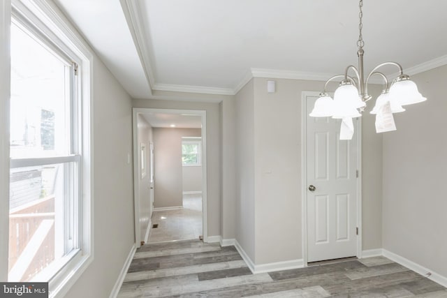 interior space with crown molding, a notable chandelier, and light wood-type flooring