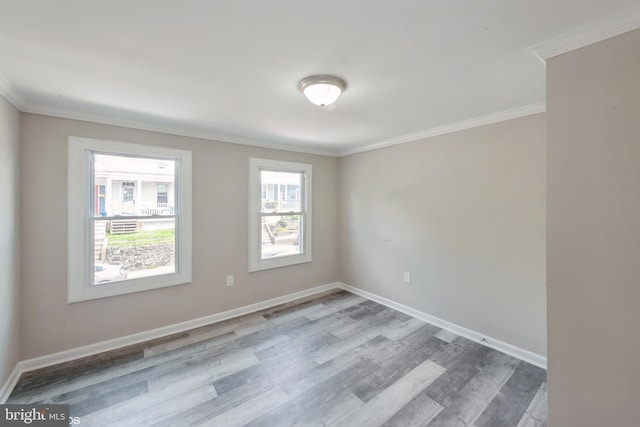 spare room with light wood-type flooring, a wealth of natural light, and ornamental molding