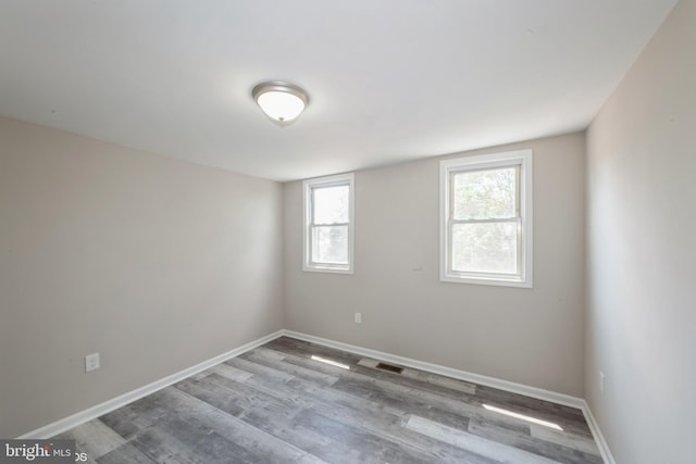 unfurnished room with hardwood / wood-style flooring