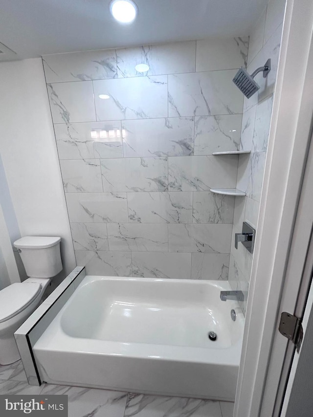 bathroom featuring tiled shower / bath combo and toilet