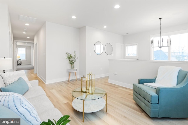 living room featuring light wood-type flooring and an inviting chandelier