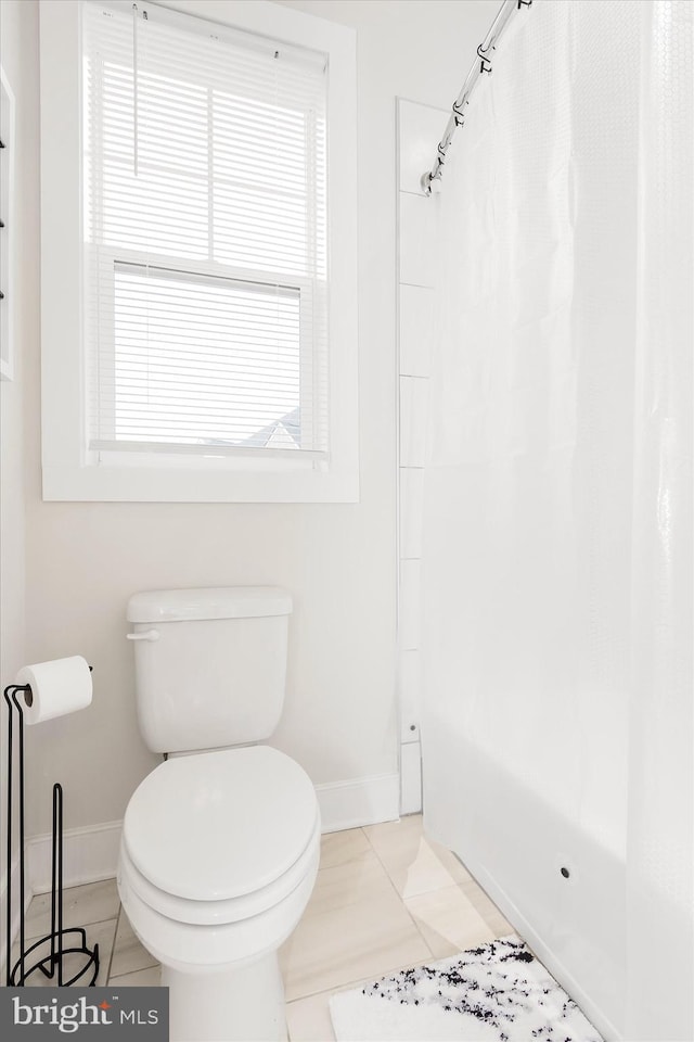 bathroom with tile patterned flooring, a shower with curtain, and toilet