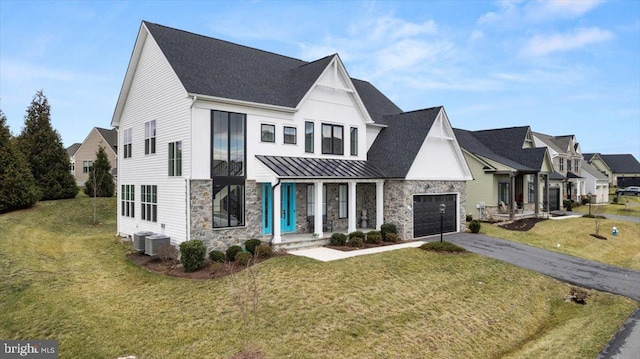 modern farmhouse style home featuring cooling unit, a garage, and a front yard