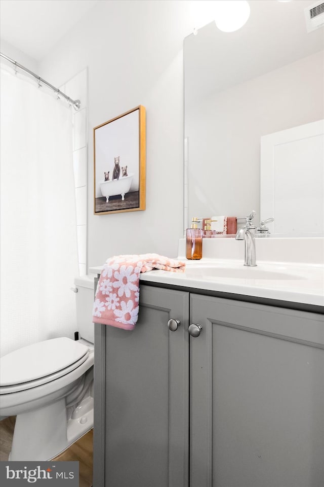 bathroom featuring hardwood / wood-style flooring, vanity, toilet, and a shower with shower curtain