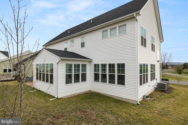 rear view of house with a yard and central AC