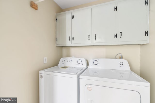 washroom featuring cabinets and independent washer and dryer