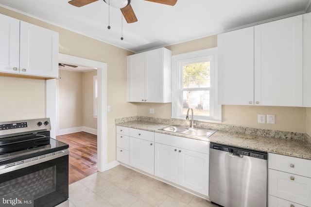 kitchen with white cabinets, appliances with stainless steel finishes, light wood-type flooring, and sink