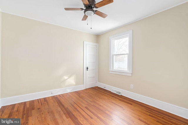 empty room featuring hardwood / wood-style flooring, ceiling fan, and crown molding