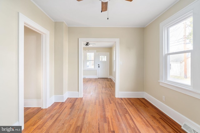 hall featuring light wood-type flooring and crown molding