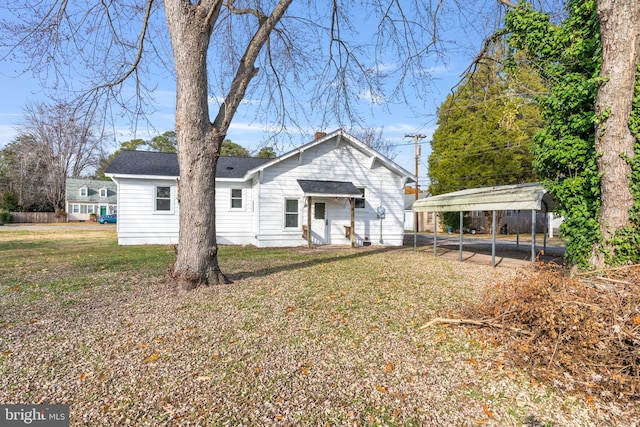 rear view of house with a yard and a carport