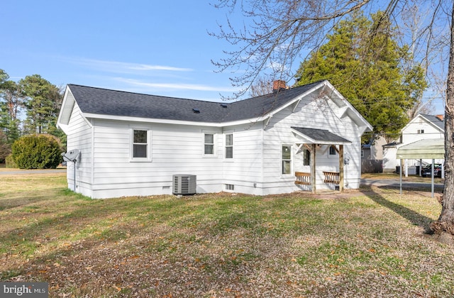 rear view of house featuring a lawn and cooling unit