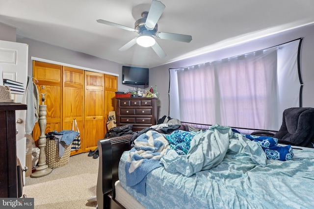 carpeted bedroom featuring ceiling fan and a closet