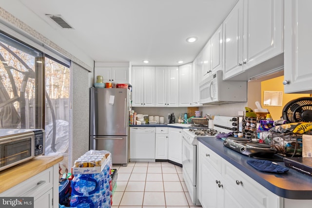 kitchen featuring light tile patterned floors, appliances with stainless steel finishes, and white cabinetry