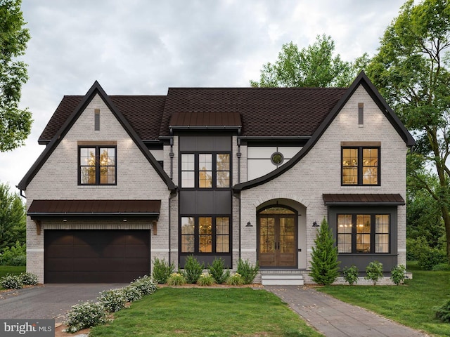 view of front of home featuring french doors, a garage, and a front lawn