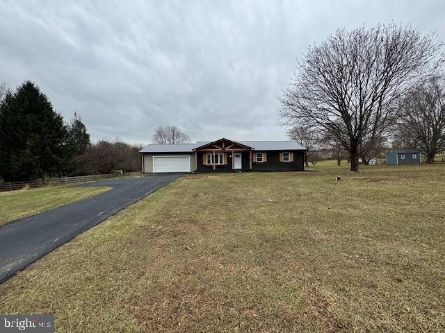 ranch-style house with a garage and a front lawn