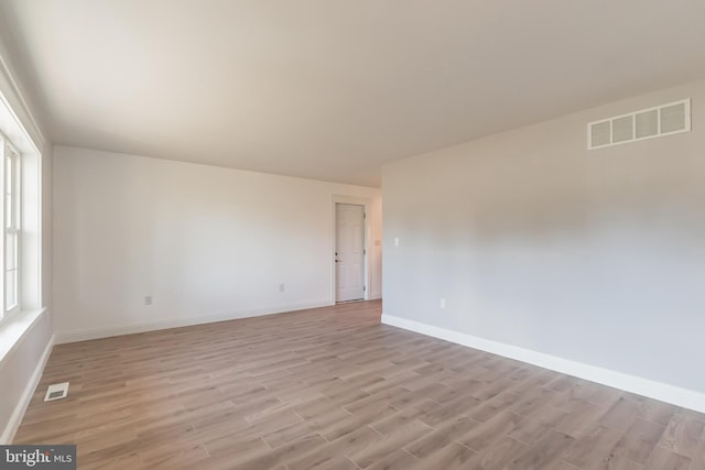 spare room featuring light hardwood / wood-style floors and plenty of natural light