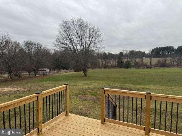 deck with a rural view and a lawn