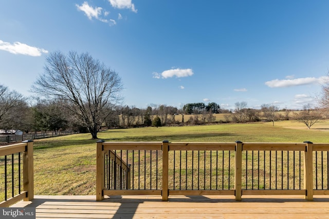 deck with a lawn and a rural view