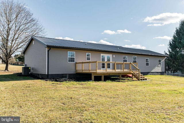 rear view of property with a yard, cooling unit, and a deck