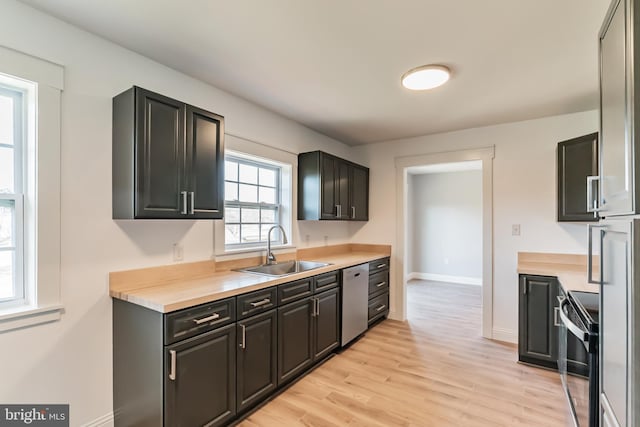 kitchen with light hardwood / wood-style floors, sink, stainless steel dishwasher, and black range with electric cooktop